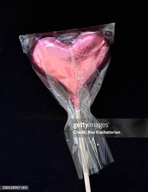 chocolate heart on stick, wrapped in cellophane, close-up - cellophane stock pictures, royalty-free photos & images