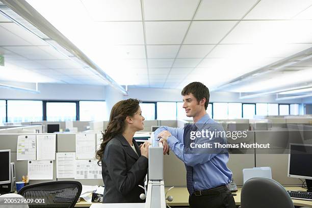 two executives having conversation over cubicle wall, side view - kantoorromance stockfoto's en -beelden