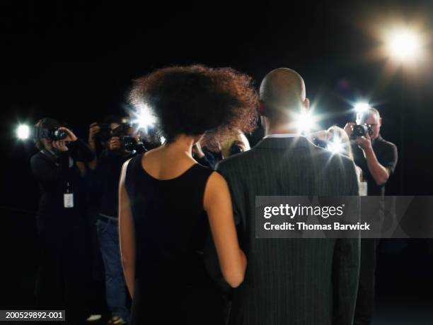 young man and woman being photographed by group of photographers - group fashion show ストックフォトと画像