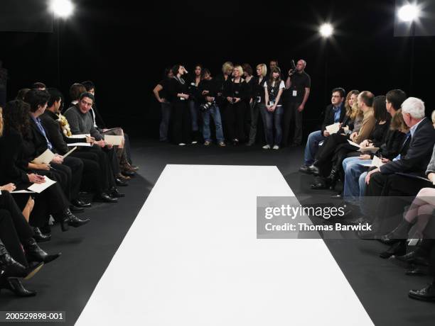 spectators and photographers surrounding catwalk at fashion show - catwalk runway stock pictures, royalty-free photos & images