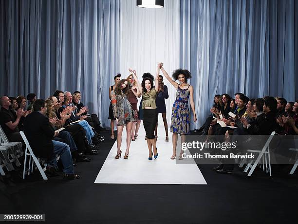 spectators applauding for designer and female models on catwalk - fashion show stage stock pictures, royalty-free photos & images