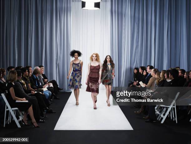 three female models walking down runway - fashion show stock-fotos und bilder
