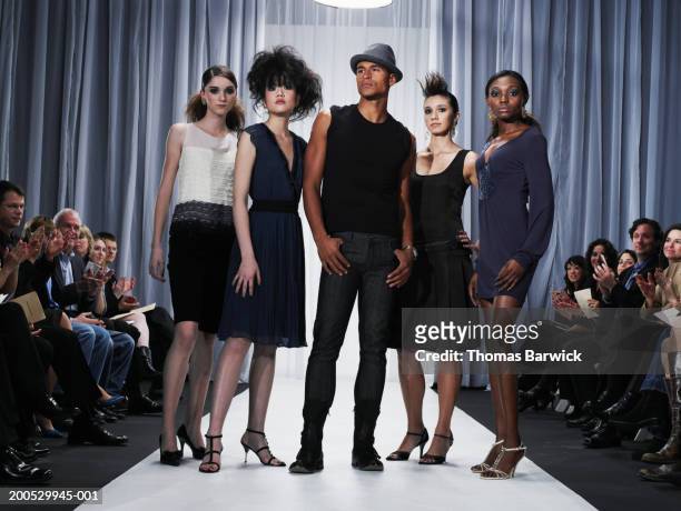designer and female models standing on catwalk - show girls stockfoto's en -beelden