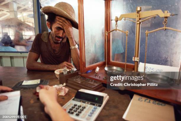 Nov 1996, Para State. Brazil, Serra Pelada Gold Mine, miner selling gold at counter.