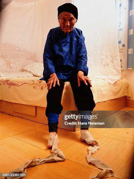 china, senior woman on bed, feet wrappings unbound - foot binding stock pictures, royalty-free photos & images