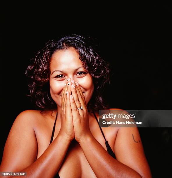 young woman smiling, holding hands to face - dekolletage foto e immagini stock