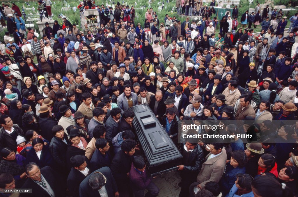 Bolivia, Llallagua, bearers carrying coffin through crowd of mourners