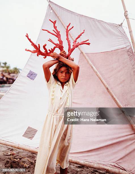 girl (9-11) in front of tent holding red coral above head - povo rom - fotografias e filmes do acervo