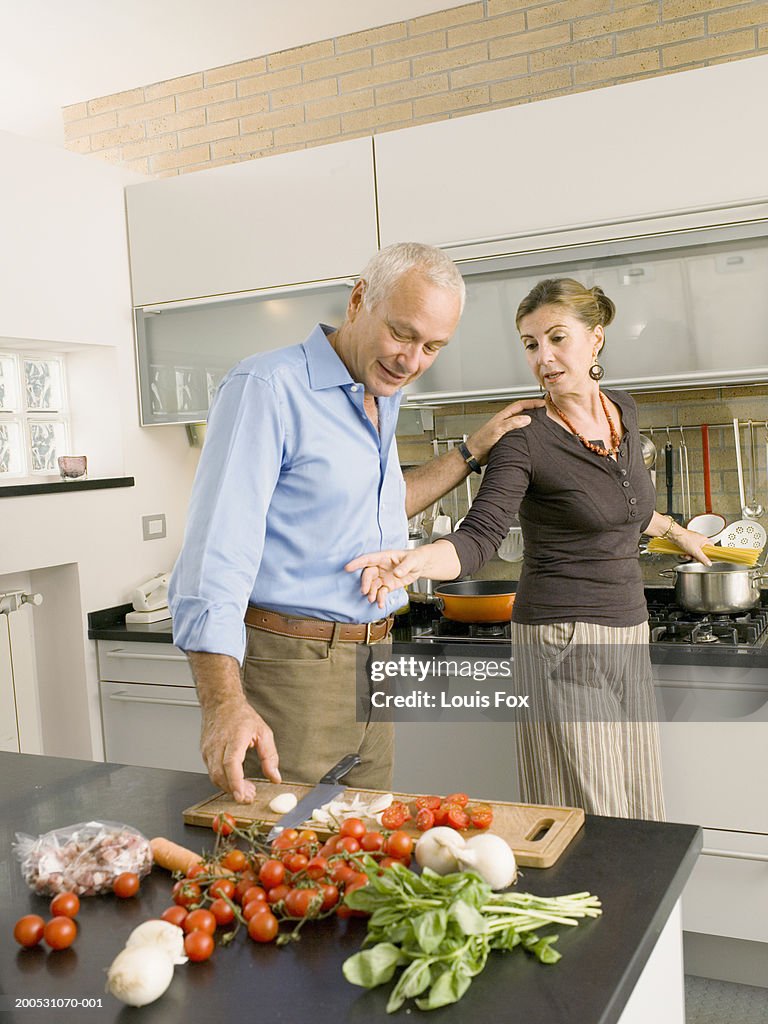 Mature couple cooking together in kitchen