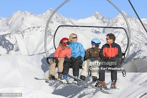 mother, father and two children (8-10) sitting on ski lift - ski lift stock pictures, royalty-free photos & images