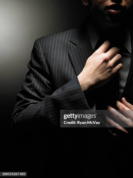 young businessman adjusting tie, mid section - striped tie stock pictures, royalty-free photos & images
