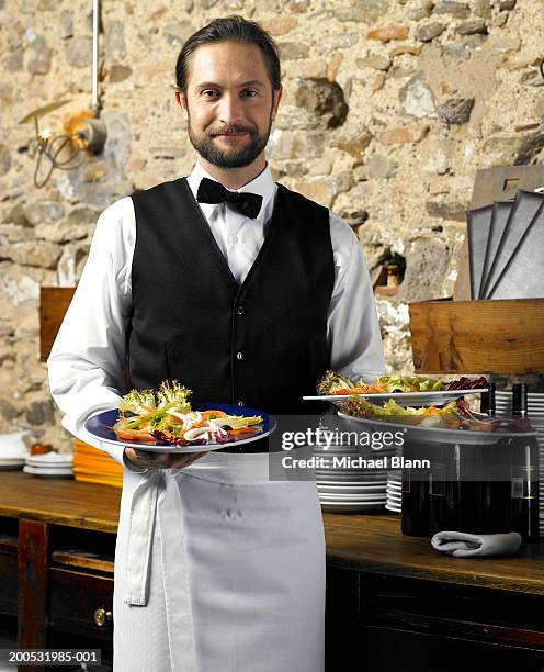 waiter holding three plates of salad, smiling, portrait - servitör bildbanksfoton och bilder