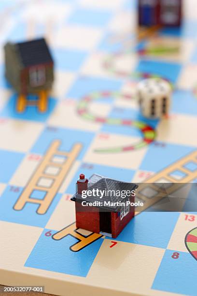 model house on snakes and ladders board game - snakes and ladders stock pictures, royalty-free photos & images