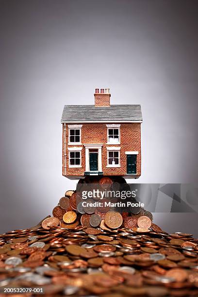model of house on pile of copper coins - copper detail stock pictures, royalty-free photos & images