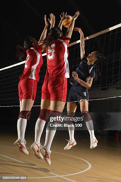three young women jumping to spike volleyball - volleyball player stock pictures, royalty-free photos & images