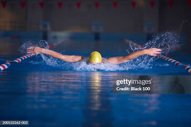 young male swimmer doing butterfly stroke in swimming lane - arm length stock pictures, royalty-free photos & images