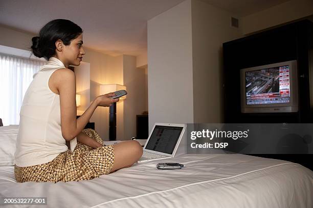 businesswoman on hotel bed watching financial news - tv room side imagens e fotografias de stock