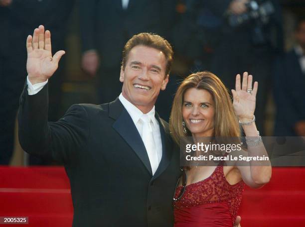 Actor Arnold Schwarzenegger with his wife Maria Shriver wave to fans as the couple arrives for the screening of the film "Les Egares" at the Palais...