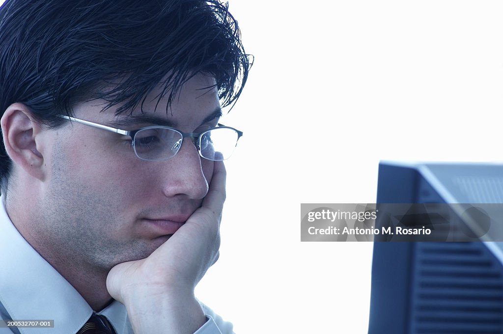 Young businessman using computer, close-up, side view