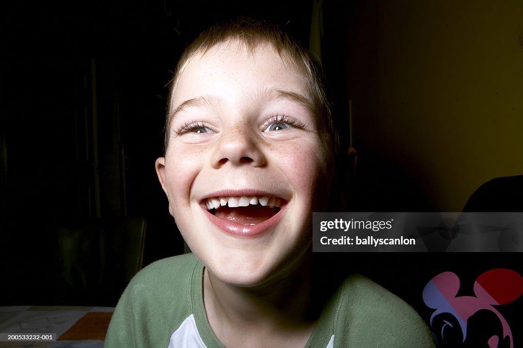 Boy (7-8) laughing, close-up