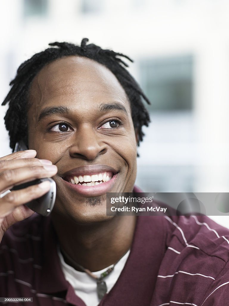 Man talking on cell phone, smiling, looking away