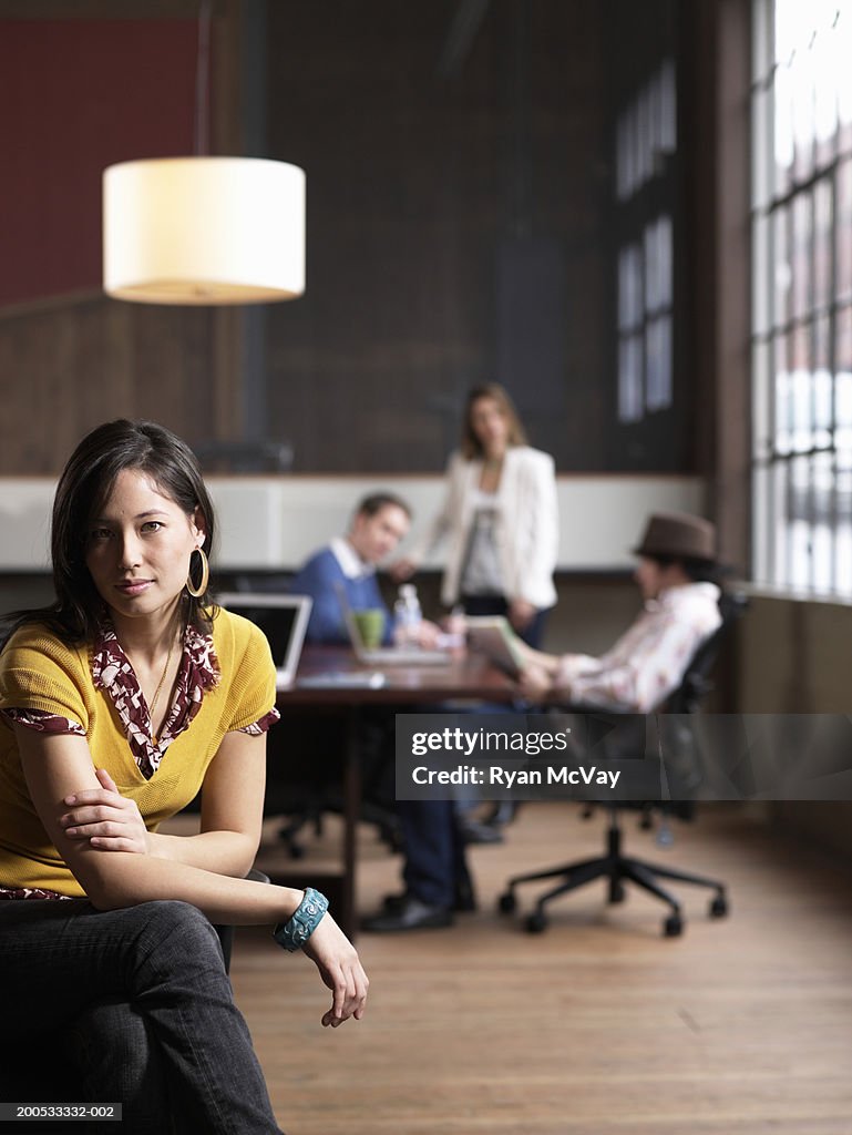 Four executives in office (focus on young woman in foreground)