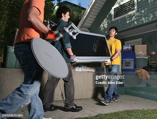 young men moving flat screen television into house - alter tv stock pictures, royalty-free photos & images