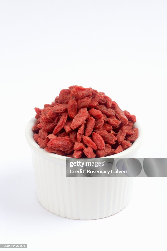 Bowl of dried goji berries, against white background, close-up