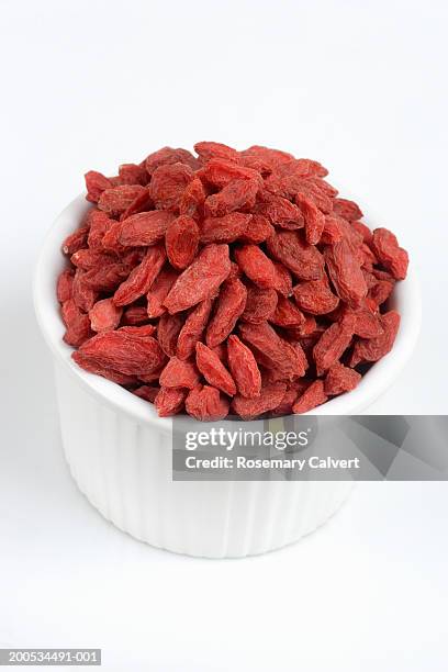 bowl of dried goji berries, against white background, close-up - wolfberry stock pictures, royalty-free photos & images