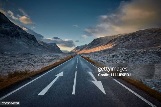 road leading into the distance in scottish highland winter landscape - wonderlust stock-fotos und bilder