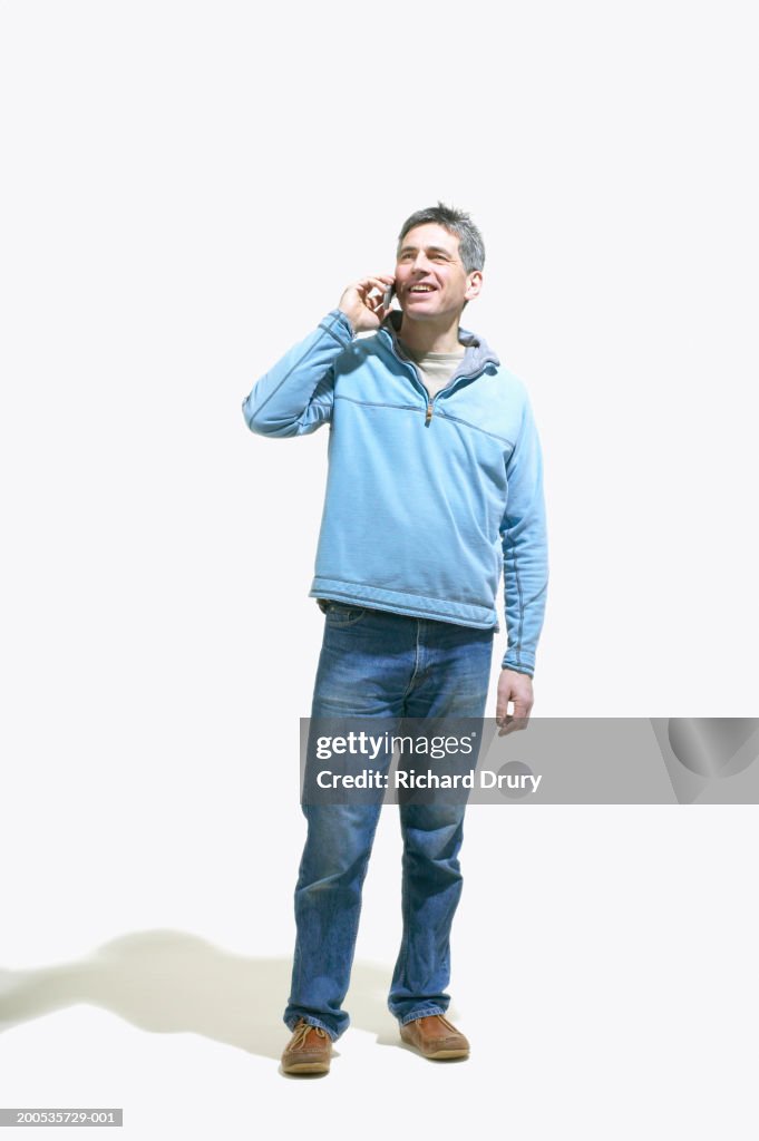 Mature man using mobile phone, smiling