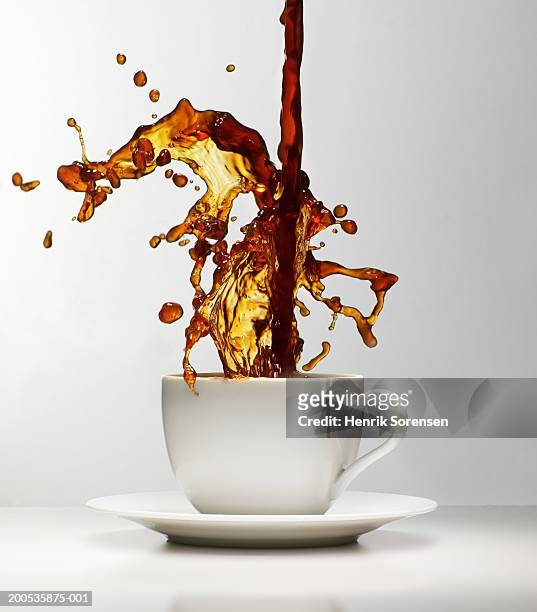coffee being poured splashing in cup - coffee drip ストックフォトと画像