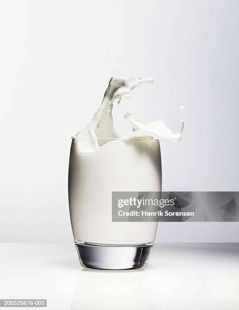milk splashing out of drinking glass - glass of milk stock pictures, royalty-free photos & images