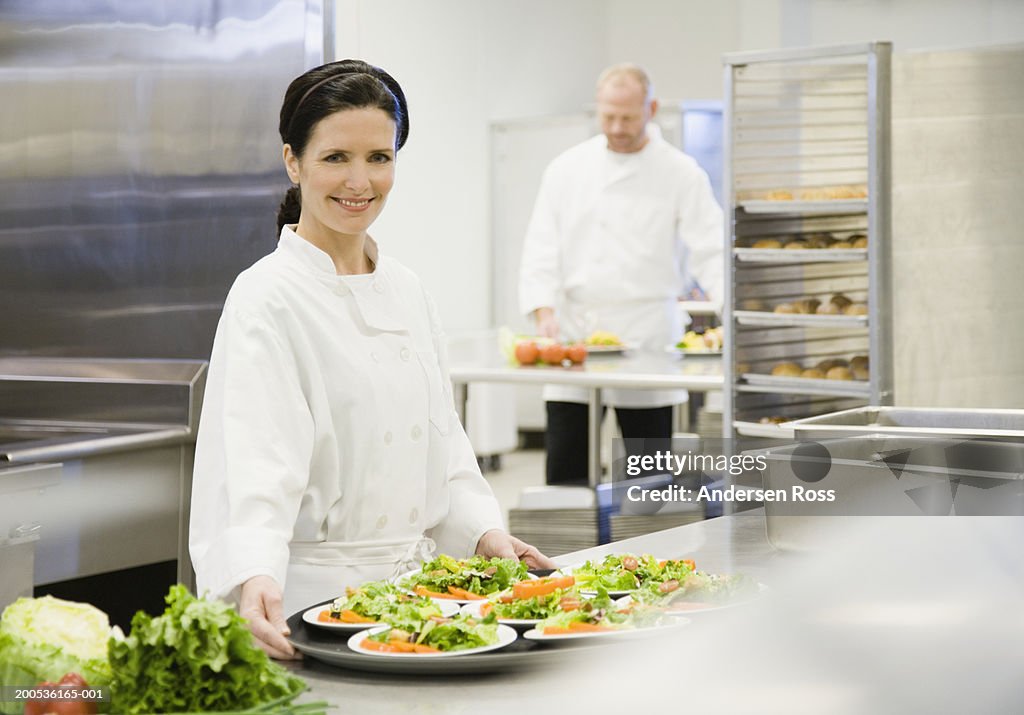 Two chefs in commercial kitchen (focus on woman in foreground)