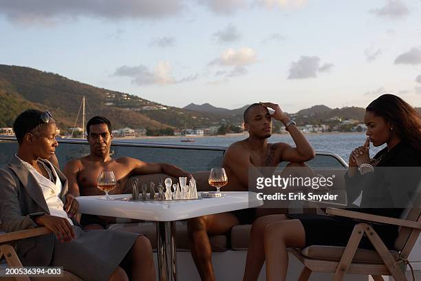 businesswomen playing chess on yacht, men relaxing in background - spirit 32 ストックフォトと画像