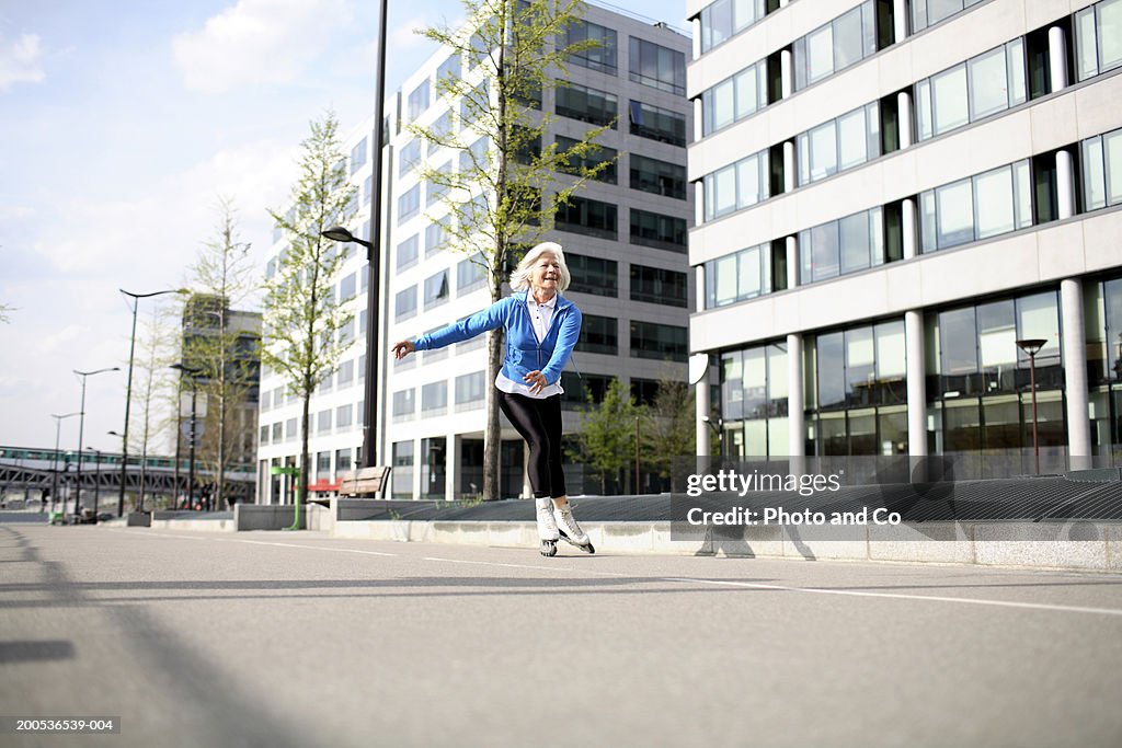 Senior woman in line skating on pavement