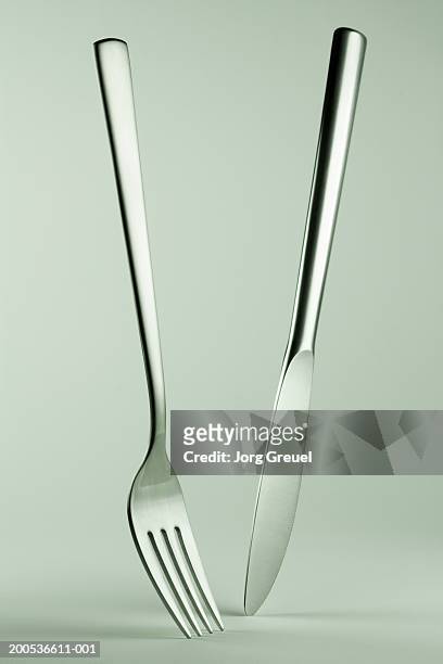 knife and fork standing on tips, close-up - tafelmes stockfoto's en -beelden