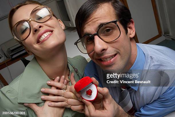 male office worker presenting heart ring to female colleague, portrait - colleague engagement stock pictures, royalty-free photos & images