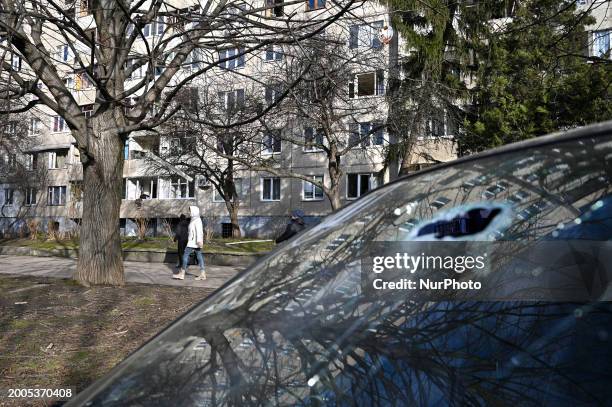 Woman is walking past an apartment building with smashed windows after a Russian missile attack in Lviv, Ukraine, on February 15, 2024. In the early...