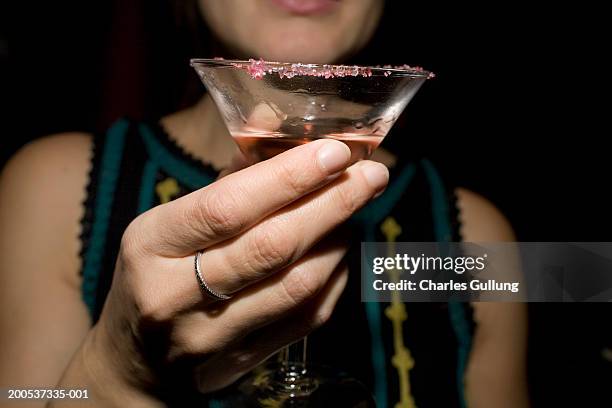 woman holding cocktail in martini glass, mid section - socialite stock-fotos und bilder