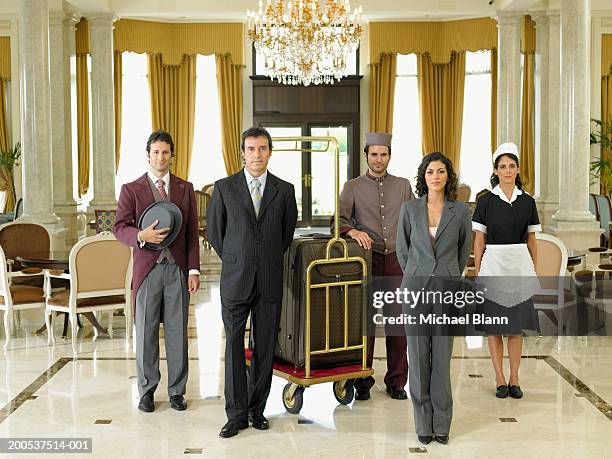 hotel staff standing in foyer, portrait - bellhop foto e immagini stock