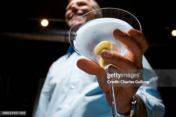 mature man holding martini, low angle view (focus on martini) - low alcohol drink stock pictures, royalty-free photos & images