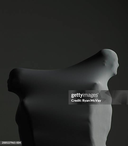 man and woman enveloped in sheath, standing back to back, side view - brume fond noir photos et images de collection