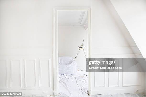 ladder by sofa covered in dust sheet in room, view through doorway - doorway 個照片及圖片檔