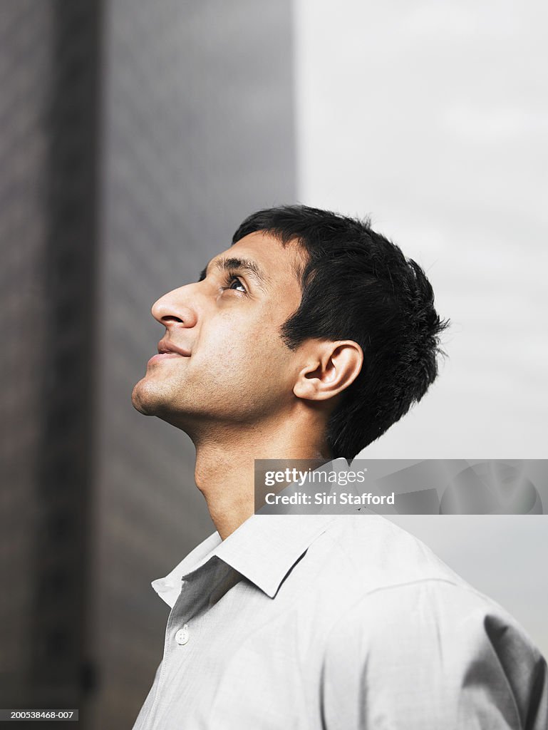 Young businessman looking up, profile