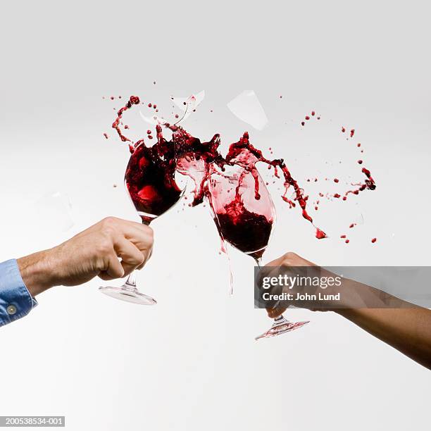 man and woman crashing wine glasses together (digital composite) - hand glasses stockfoto's en -beelden