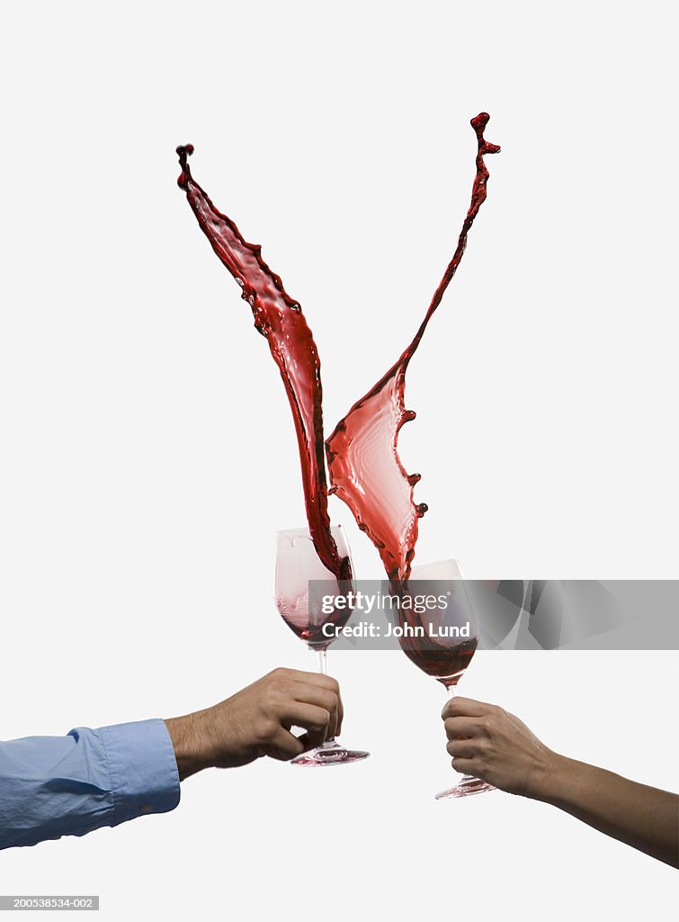 Man and woman crashing wine glasses together (Digital Composite)
