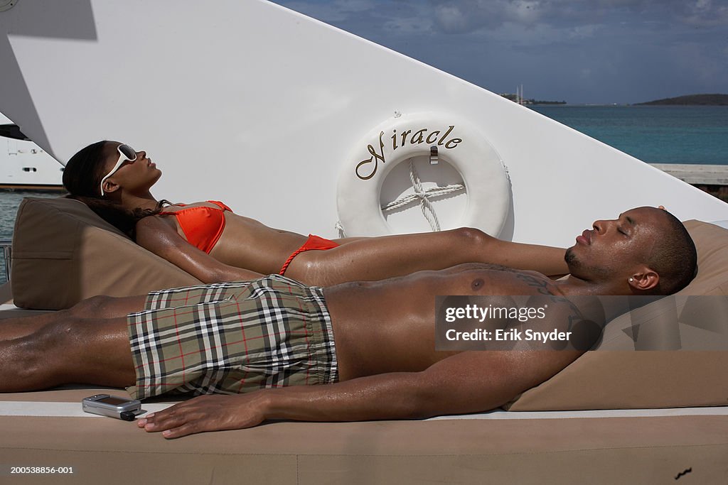 Young couple sunbathing on yacht