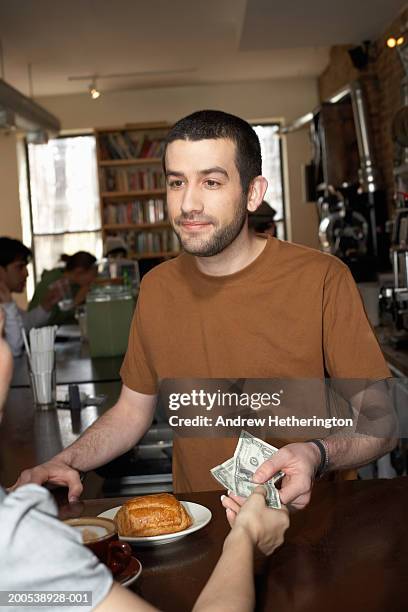 counterman giving woman change in cafe - the bartenders stock pictures, royalty-free photos & images