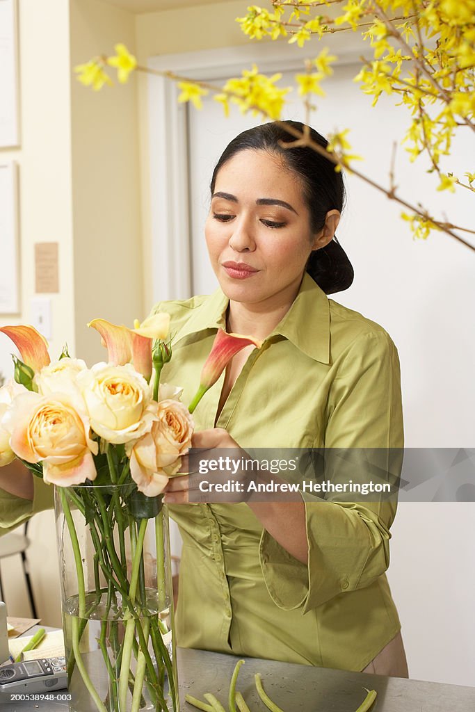Female florist arranging flowers in vase